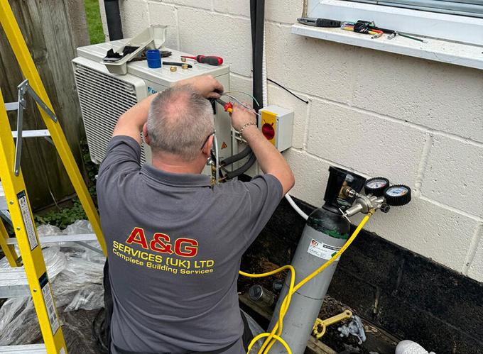 man installing heat pump in to property in the UK